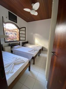 乌巴图巴Giprita Wellness Hotel Ubatuba的带三张床、窗户和门的房间