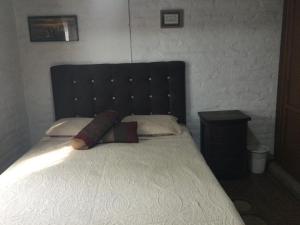 卡利Beautiful Colonial House的一间卧室配有一张大床和黑色床头板