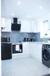 哈罗Stunning 2-Bed Apartment in Harrow的厨房配有洗衣机和洗衣机。
