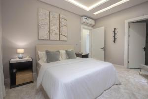 利雅德Spacious and Modern Apartment for Rent in Ergah, Riyadh的白色的卧室配有一张白色的大床和一张桌子