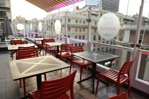圣地亚哥Hotel Sommelier Agustinas的阳台,餐厅配有桌椅