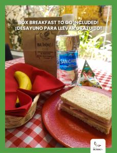 库斯科Eco Bunnu Inn的桌上的红色盘子上的三明治,上面有盒子和香蕉