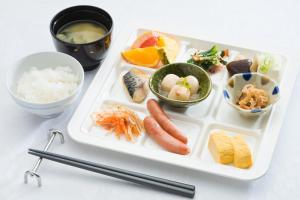 金泽金泽花园酒店的盘子里放有寿司和其他食物的食品