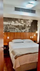 圣保罗Flat em Hotel na Bela Cintra próximo à Paulista e Consolação的卧室配有一张大床,墙上挂有绘画作品