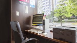 东京东品川哈顿酒店的一张桌子,上面有一台电脑和打印机