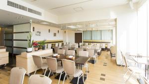 东京东品川哈顿酒店的一间在房间内配有白色椅子和桌子的餐厅
