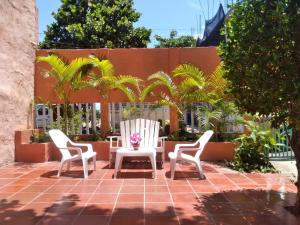 卡塔赫纳Casa de Playa Nativo的庭院里设有两把白色的椅子和一张桌子