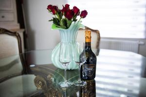 斯帕La Sentinelle Gite的桌子上放有一瓶葡萄酒和两杯酒