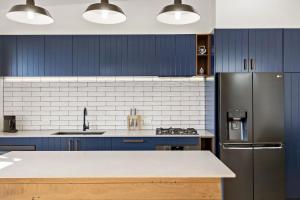 纽卡斯尔The Stables at the Hill的厨房配有蓝色橱柜和不锈钢冰箱