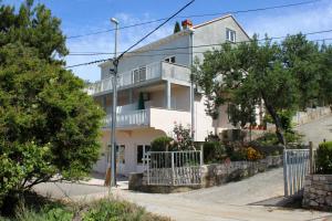 莫鲁纳特Apartments by the sea Molunat, Dubrovnik - 8956的街道上带阳台的白色房屋