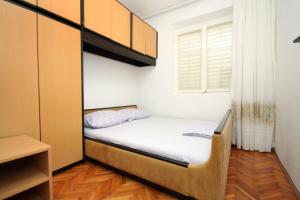 杜布罗夫尼克Apartments with a parking space Dubrovnik - 9099的一间小卧室,配有床和窗户