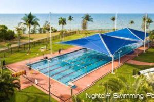 NightcliffZEN FORESHORE: 3-BR Nightcliff Foreshore-Front Apt的一座蓝色遮盖的大型游泳池