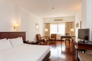 万象Le Charme Vientiane Hotel的配有一张床和一台平面电视的酒店客房