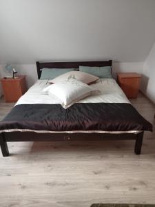 KrośnicaNa wzgórzu的一张带白色床单和枕头的床