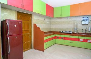 罗纳瓦拉Chandra Villa 12Bhk Lonavala的厨房配有色彩缤纷的橱柜和红色冰箱