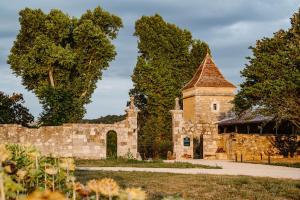 雷克图尔Domaine de Boulouch的一座古老的石头建筑,有塔和栅栏
