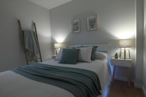 维戈Apartamento Mar de Ardora的一间卧室配有一张带蓝色和白色床单的床。