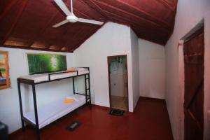 锡吉里亚Sigiri Peace Hostel的客房配有双层床和吊扇。