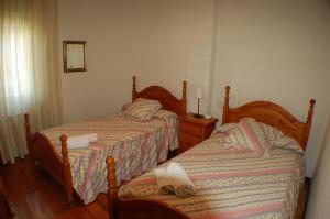 雷诺萨Apartamentos La Luz de Reinosa 2的一间卧室配有两张带毛巾的床