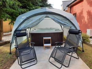 布莱尔高里Fir Tree Cottage的帐篷内的两把椅子和热水浴池
