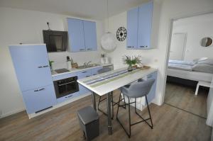 Lütow桑德拉公寓的厨房配有蓝色橱柜和桌椅