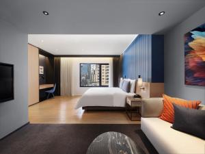 曼谷曼谷新浩中央酒店 - an IHG Hotel的酒店客房,配有床和沙发