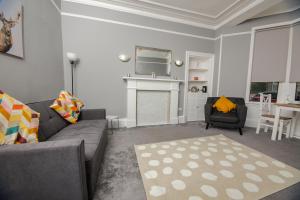 邓巴顿Bonhill Getaway的客厅设有灰色的沙发和壁炉