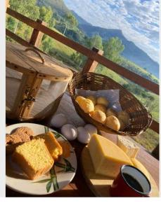 瓦尔任博尼塔Pousada Chales da Canastra的一张桌子,上面放着一盘面包和一篮奶酪