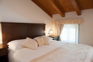 Doberdò del Lago帕霍尔餐厅酒店的卧室设有一张白色大床和一扇窗户。