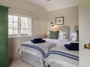 赫特福德The Walled Garden at Woodhall Estate的一间卧室配有两张床和蓝色毛巾。