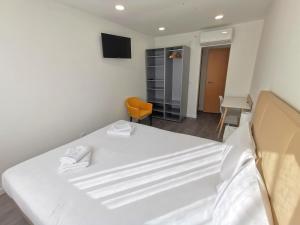 卡帕里卡海岸Vila Alexandra的卧室配有白色的床和椅子