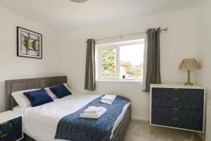 诺丁汉Alderton House - Spacious 3 Bed with Parking的一间卧室设有一张床和一个窗口
