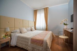 博洛尼亚Hotel Re Enzo的酒店客房设有一张大床和一张桌子。