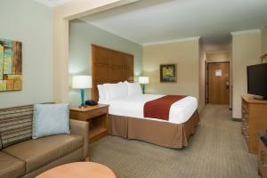 圣克拉拉圣克拉拉硅谷快捷假日&套房酒店的酒店客房设有一张大床和一张沙发。