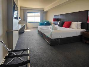 达尔文ZEN88 ESPLANADE: Hotel Suite w/ Ocean/Sunset Views的酒店客房设有一张大床和一台电视。