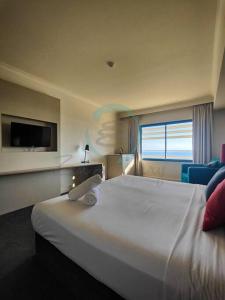 达尔文ZEN88 ESPLANADE: Hotel Suite w/ Ocean/Sunset Views的酒店客房设有一张白色大床和一台电视。