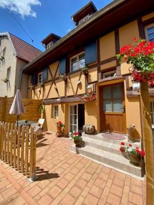 万泽内姆Coeur d'Alsace Colmar Vignobles Ouest avec terrasses的前面有围栏和鲜花的房子