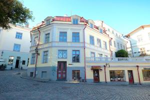 塔林Tallinn City Apartments - Old Town Townhouse的鹅卵石街道上一座白色的大建筑