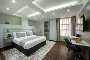 内罗毕Hotel Mokka City的配有一张床和一张书桌的酒店客房