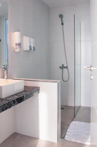 玛德琳港CQ MITRE的白色的浴室设有水槽和淋浴。
