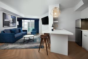 多伦多多伦多中心潘塔基斯酒店的厨房以及带蓝色沙发的客厅。