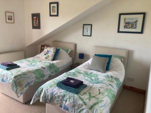 爱丁堡Midkinleith Farm Holiday Cottage的一间带两张床的卧室和楼梯