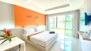 Takua Pa瓜巴度假酒店的一间卧室配有一张橙色墙壁的床