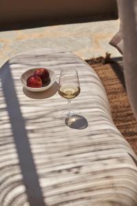提诺斯Under the Sun Cycladic Village的坐在桌子上喝一杯酒,喝一碗苹果