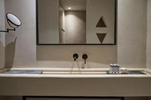 提诺斯Under the Sun Cycladic Village的一间带水槽和镜子的浴室