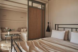 提诺斯Under the Sun Cycladic Village的一间卧室配有一张床、一张桌子和一面镜子