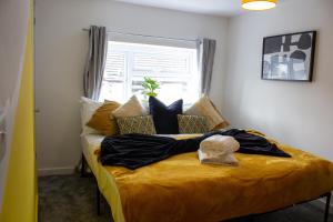 NantygloHeritage House By MGroupSA - Free Parking的一间卧室设有一张黄色的床和窗户
