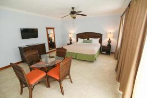 尼格瑞尔可可棕榈酒店的卧室配有一张床和一张桌子及椅子