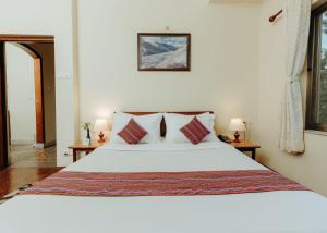 加德满都Tise Hotel的卧室配有带枕头的大型白色床
