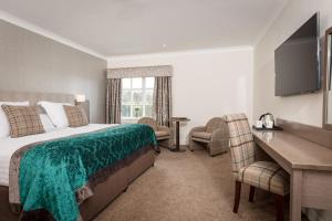 拉恩巴里加里城堡酒店的配有一张床和一张书桌的酒店客房